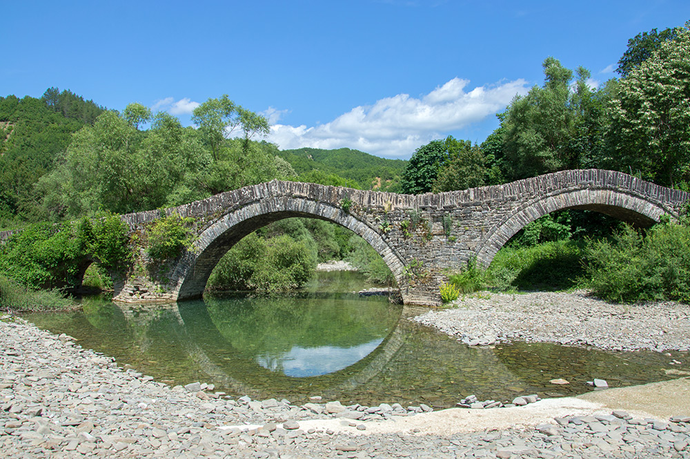 Die Milos-Brücke von 1748 liegt in, bzw. kurz hinter Kipi auf der rechten Straßenseite. Der seltene Fahrzeugverkehr wird durch eine Furt neben der Brücke geleitet.
